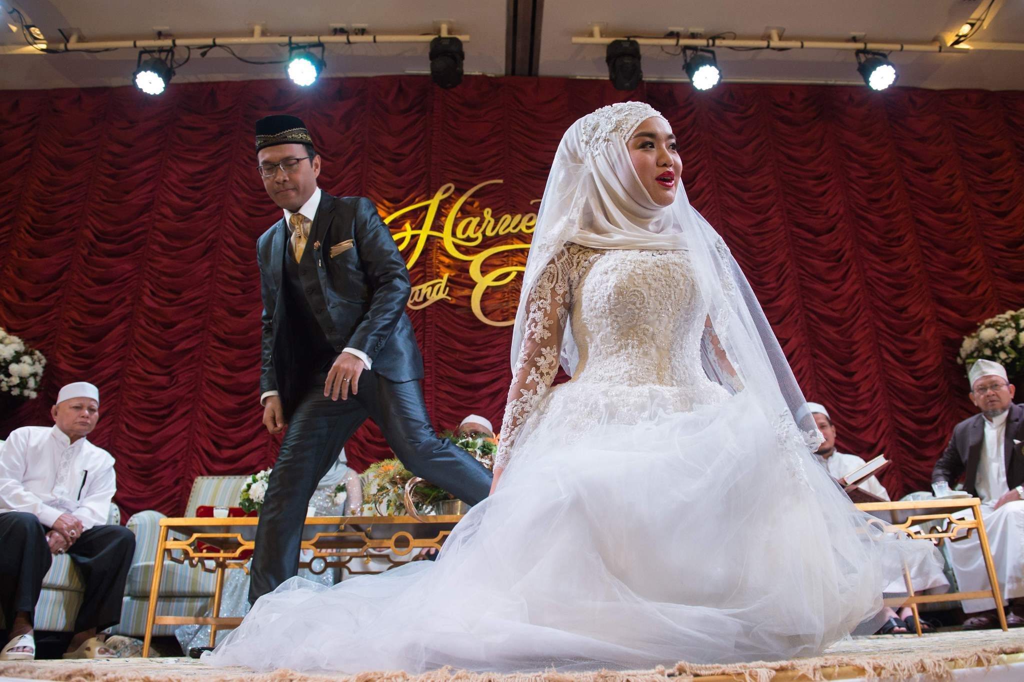 A newly married woman and her husband (2nd L) get ready to pose for a portrait during their wedding reception at the Al Meroz hotel in Bangkok.