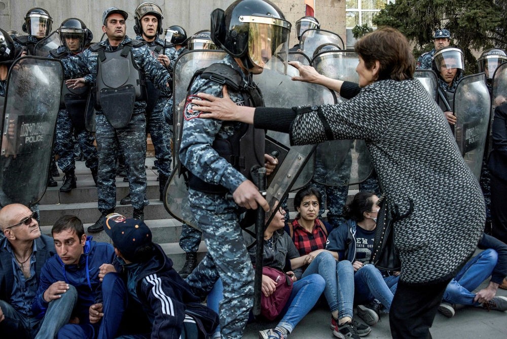 A demonstrator tries to stop riot police officer during an anti-government rally, Yerevan, April 19.
