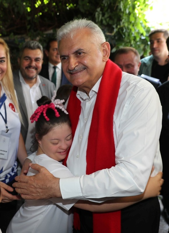 Yıldırım embraces a Turkish child with down syndrome.