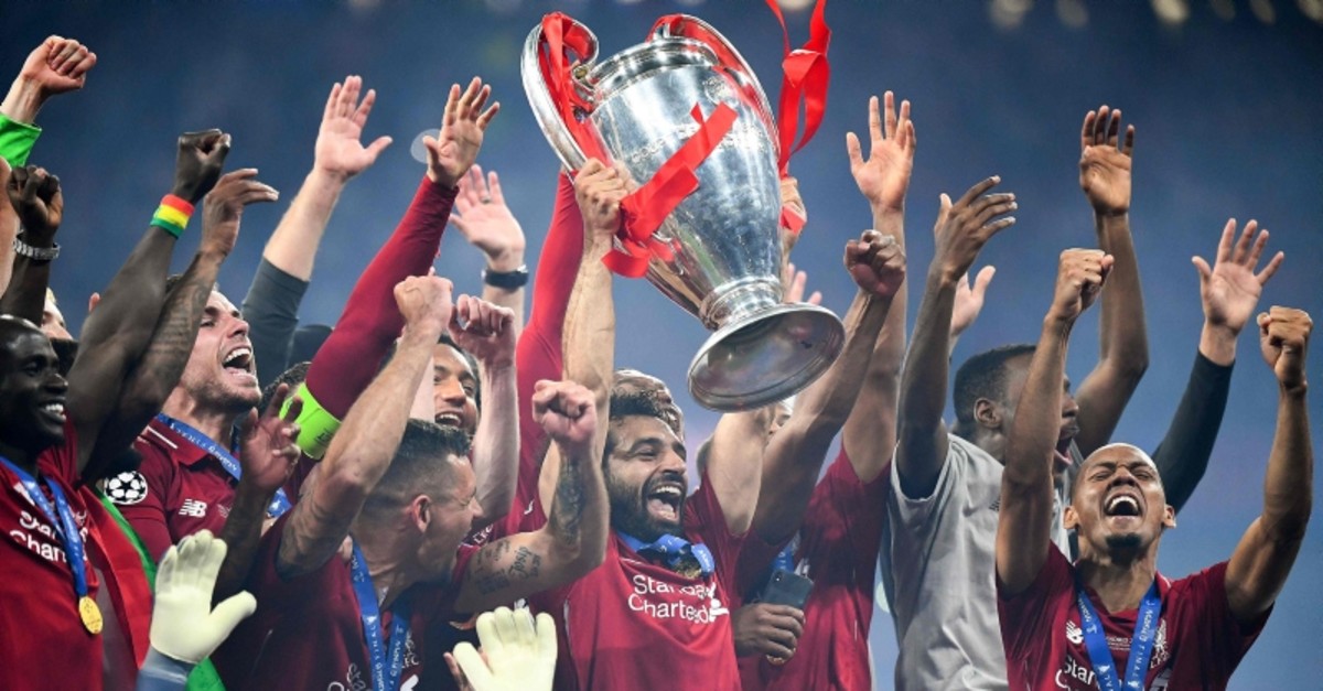 Liverpool's Egyptian forward Mohamed Salah (C) raises the European Champion Clubs' Cup as he celebrates with teammates (AFP Photo)