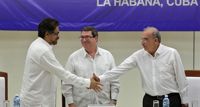 Kolumbiens FARC-Verhandlungsführer Ivan Marques links und Verhandlungsvertreter der Regierung Kolumbiens Humberto de la Calle rechts schütteln Hände während Kubas Außenminister Bruno Rodrigues zusieht. Reuters Foto