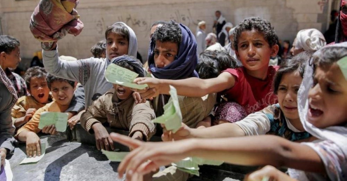 In this April 13, 2017 file photo Yemenis present documents in order to receive food rations provided by a local charity in Sanaa, Yemen. (AP Photo)