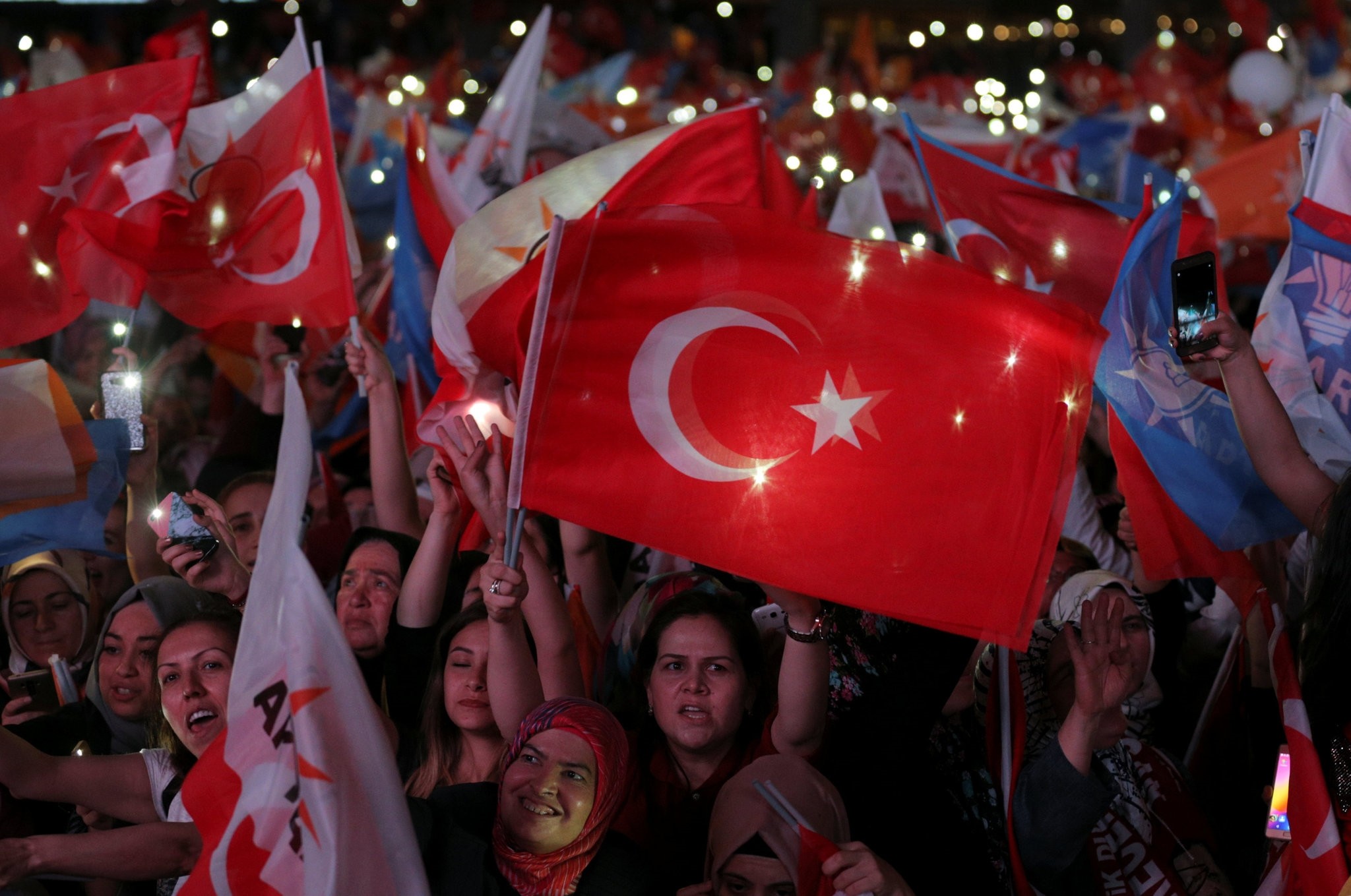 AK Party supporters wave flags to celebrate the June 24 results in front of their party's headquarters, Ankara, June 24.