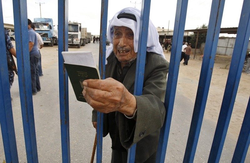 A Palestinian man holds his passport as he waits to cross into Egypt through the Rafah border crossing in the southern Gaza Strip June 27, 2009 ( File Photo) 