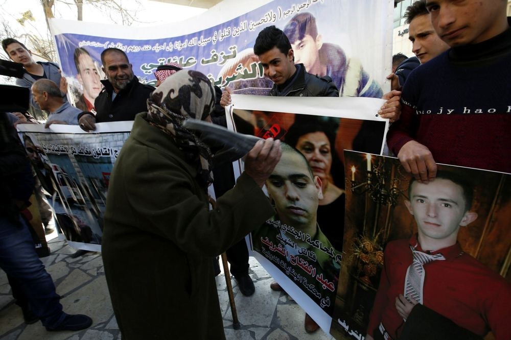 A Palestinian woman hits a photo of Israeli soldier Elor Azaria during a protest in Hebron, Jan. 21.