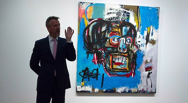  This file photo taken on May 5, 2017 shows a Sotheby's official speaking about ,Untitled,, a 1982 painting by Jean-Michel Basquiat during a media preview at Sotheby's in New York. (AFP Photo)