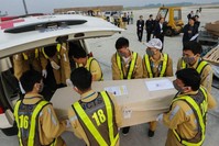Photo taken on Nov. 27, 2019, shows ground personnel of Noi Bai International Airport carrying a casket containing the remains of one of the Vietnamese victims to an ambulance in Hanoi. (VIETNMA NEWS AGENCY via AFP)