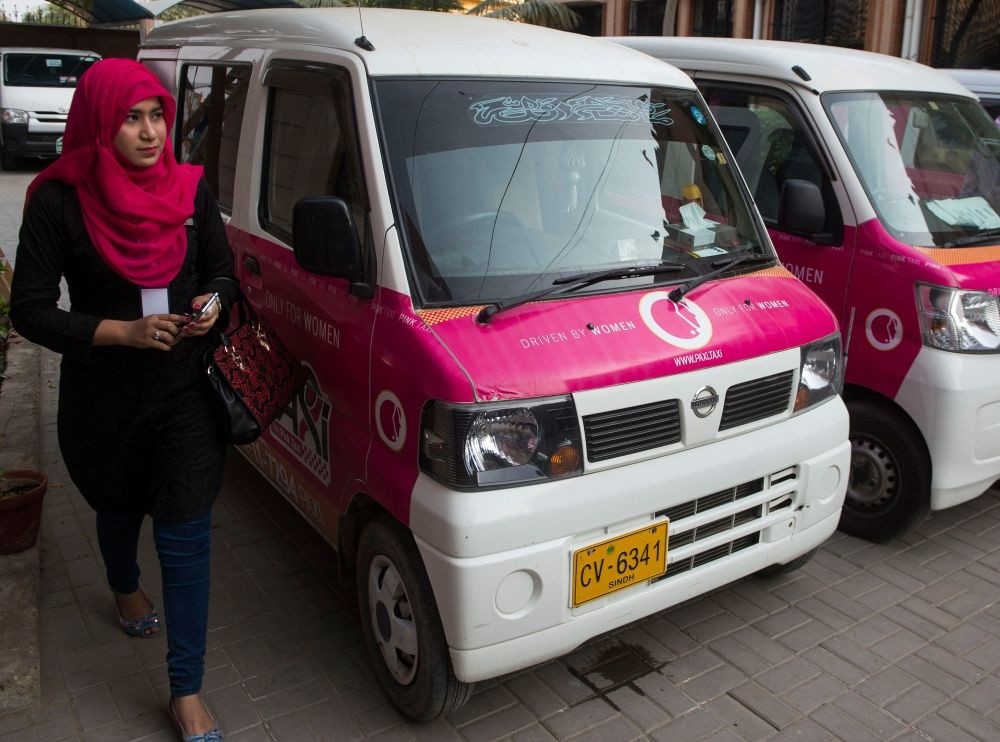 A driver with the women-only Paxi Pakistan taxi company walks past a Pink Taxi during a launch ceremony in Karachi on International Womenu2019s Day.