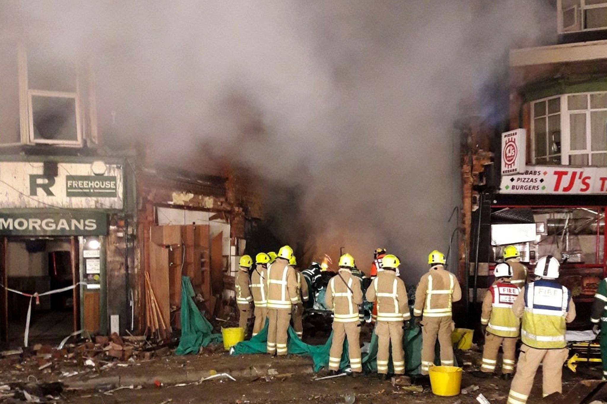 A handout picture released by Leicestershire Fire and Rescue Service on February 26, 2018 shows members of the emergency services attending the scene of an explosion in Leicester, central England, on February 25, 2018. 