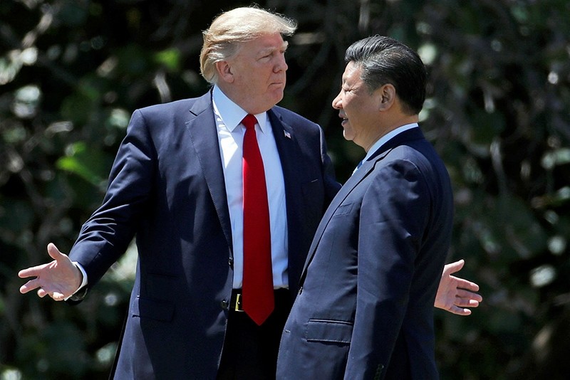 In this Friday, April 7, 2017, file photo, U.S. President Donald Trump, left, gestures as he and Chinese President Xi Jinping walk together at Mar-a-Lago in Palm Beach, Florida. (AP Photo)