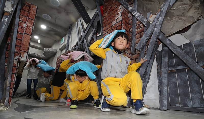 Children participate in a training program in Seoul, South Korea on Nov. 17 2017, that teaches them how to take shelter from an earthquake. (EPA Photo)