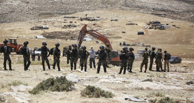 فلسطينيون يحاولون منع آلات الحفر من العمل في إنشاء مستوطنة جديدة بقرية رمون بالضفة الغربية الأناضول