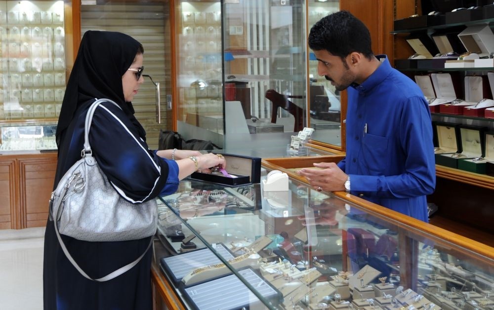A Saudi jeweler attends to a client in a shop in the Tiba gold market, Riyadh.