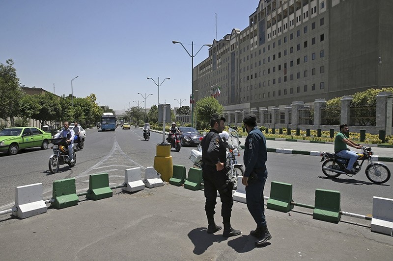 Police officers stand guard as vehicles drive past Iran's parliament building in Tehran, Iran, Thursday, May 8, 2017. (AP Photo)