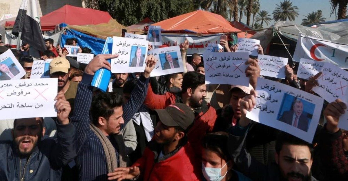 Anti-government protesters chant slogans and hold posters against the newly appointed Prime Minister Mohammed Allawi that reads, ,Rejected,, Tahrir Square, Baghdad, Feb. 2, 2020. (AP Photo)