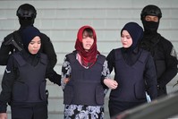 In this photo taken on March 14, 2019, Vietnamese national Doan Thi Huong (C), accused of murdering Kim Jong Nam, the half brother of North Korean leader Kim Jong Un, leaves Shah Alam High Court escorted by police, outside Kuala Lumpur. (AFP Photo)