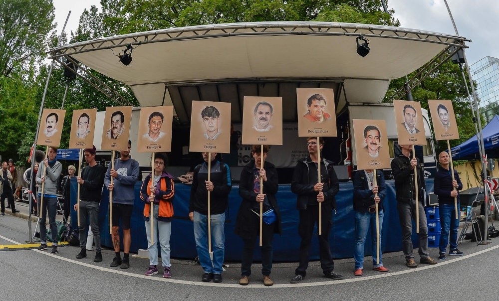 Protesters hold up signs with pictures of the victims of the Neo-Nazi cell NSU before the proclamation of a sentence in the trial against Beate Zschaepe, the only surviving member of the NSU, Munich, July 11, 2018.