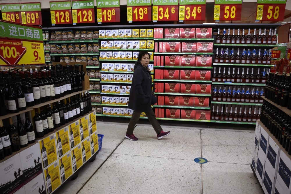 A woman walks by a section selling imported foods and beverages at Walmart in Beijing.