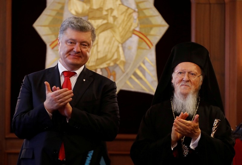 Ukraine's President Petro Poroshenko, left, and Ecumenical Orthodox Patriarch Bartholomew I applaud after their meeting at the Patriarchate in Istanbul, Nov. 3, 2018. (Reuters Photo)