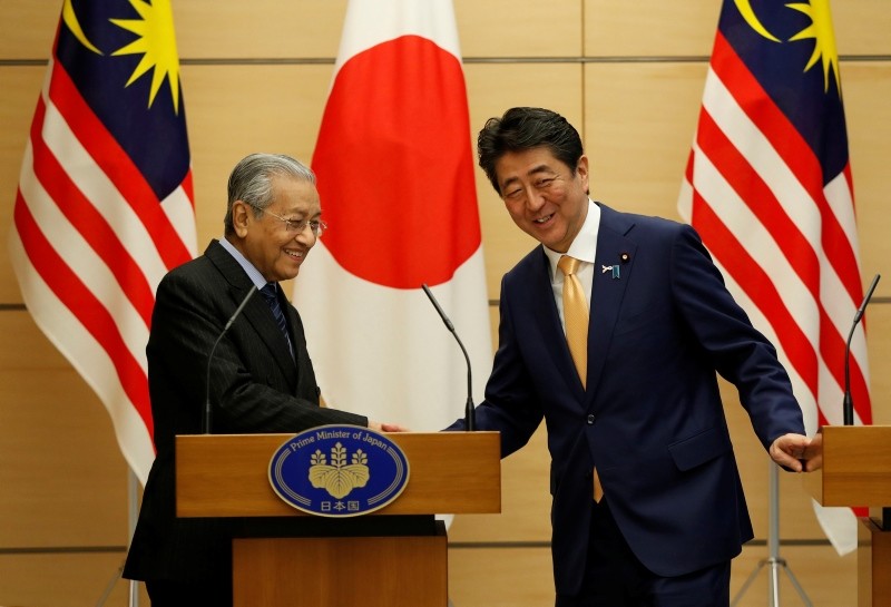 Malaysia's Prime Minister Mahathir Mohamad exchanges smiles with Japan's Prime Minister Shinzo Abe at the end of their joint news conference at Abe's official residence in Tokyo, Tuesday, Nov. 6, 2018. (Issei Kato/Pool Photo via AP)