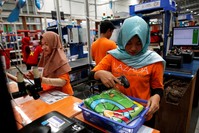 Workers package items for delivery at online retailer Lazada's warehouse in Depok, south of Jakarta, March 26.