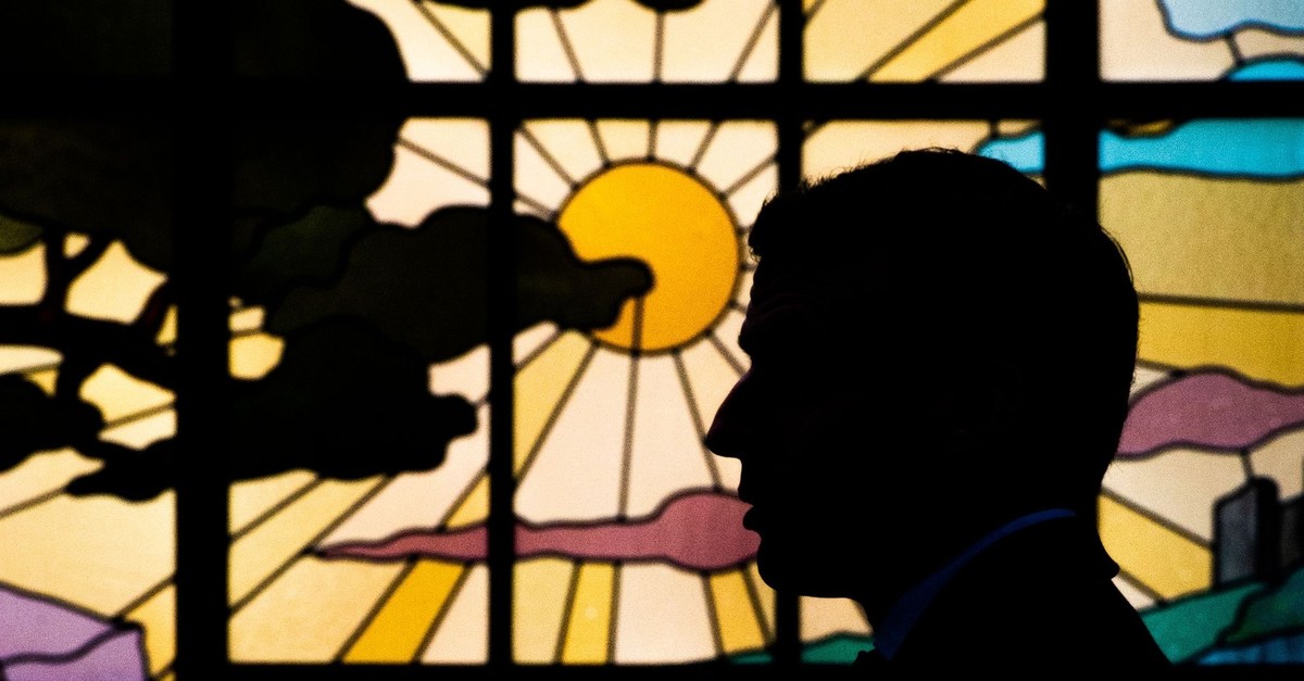French President Emmanuel Macron is silhouetted against a window as he participates in the 'Great National Debate' with local mayors, at the prefect's residence in Bordeaux on March 1, 2019.