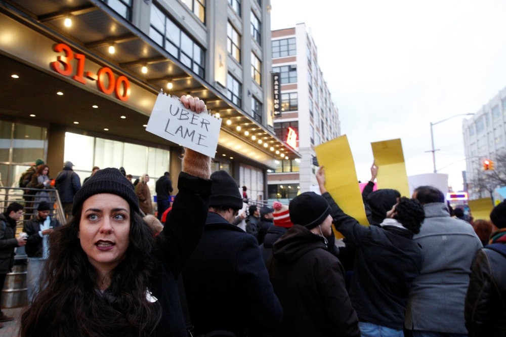People gather to protest outside the Uber offices in Queens, New York.