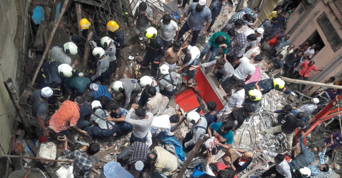 Rescue workers and residents search for survivors at the site of a collapsed building in Mumbai, India, July 16, 2019. (Reuters/Stringer)
