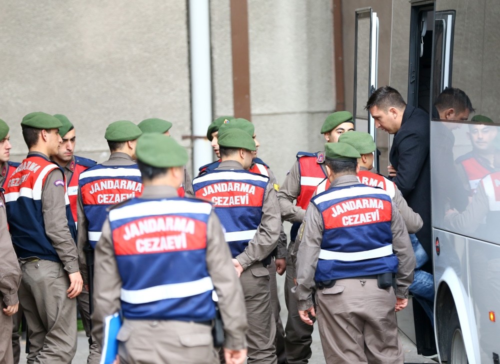 Gendarmerie officers escort a defendant stepping out of a bus into the courtroom before a trial of pro-coup troops in Ankara.