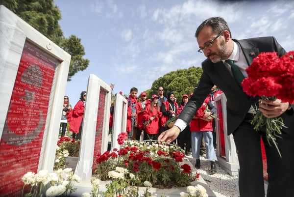 Muharrem Kasapoğlu, Turkey's youth and sports minister, laid carnations on the graves of soldiers with Turks visiting the war memorial. (AA Photo)