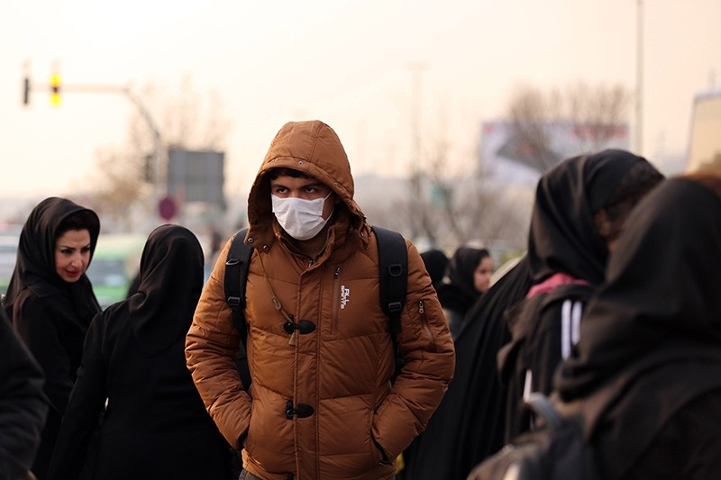 An Iranian schoolboy wears a facemask as he walks in a heavily polluted area in Tehran on Dec. 19, 2015. (AFP P`hoto)