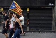 People walk past a closed store during a general strike called by Catalan unions in Barcelona. More than 2,700 companies including small and medium enterprises have moved their headquarters out of Catalonia and the list continues to grow. 