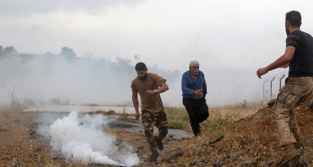 متظاهرون لبنانيون يختبئون من قنابل الغاز المسيل للدموع، التي أطلقها جنود إسرائيليون، خلال مظاهرة بالقرب من منطقة الخط الأزرق في قرية كفر شوبا جنوبي لبنان، 9-6-2023 صورة: AFP