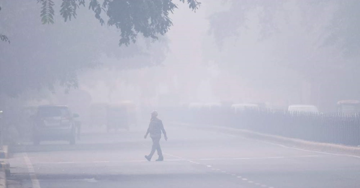 A man crosses a street in smoggy conditions in New Delhi, Nov. 4, 2019. (AFP Photo)