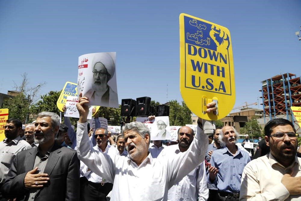 Iranian protestors hold banners in the capital Tehran during a demonstration on May 26. 