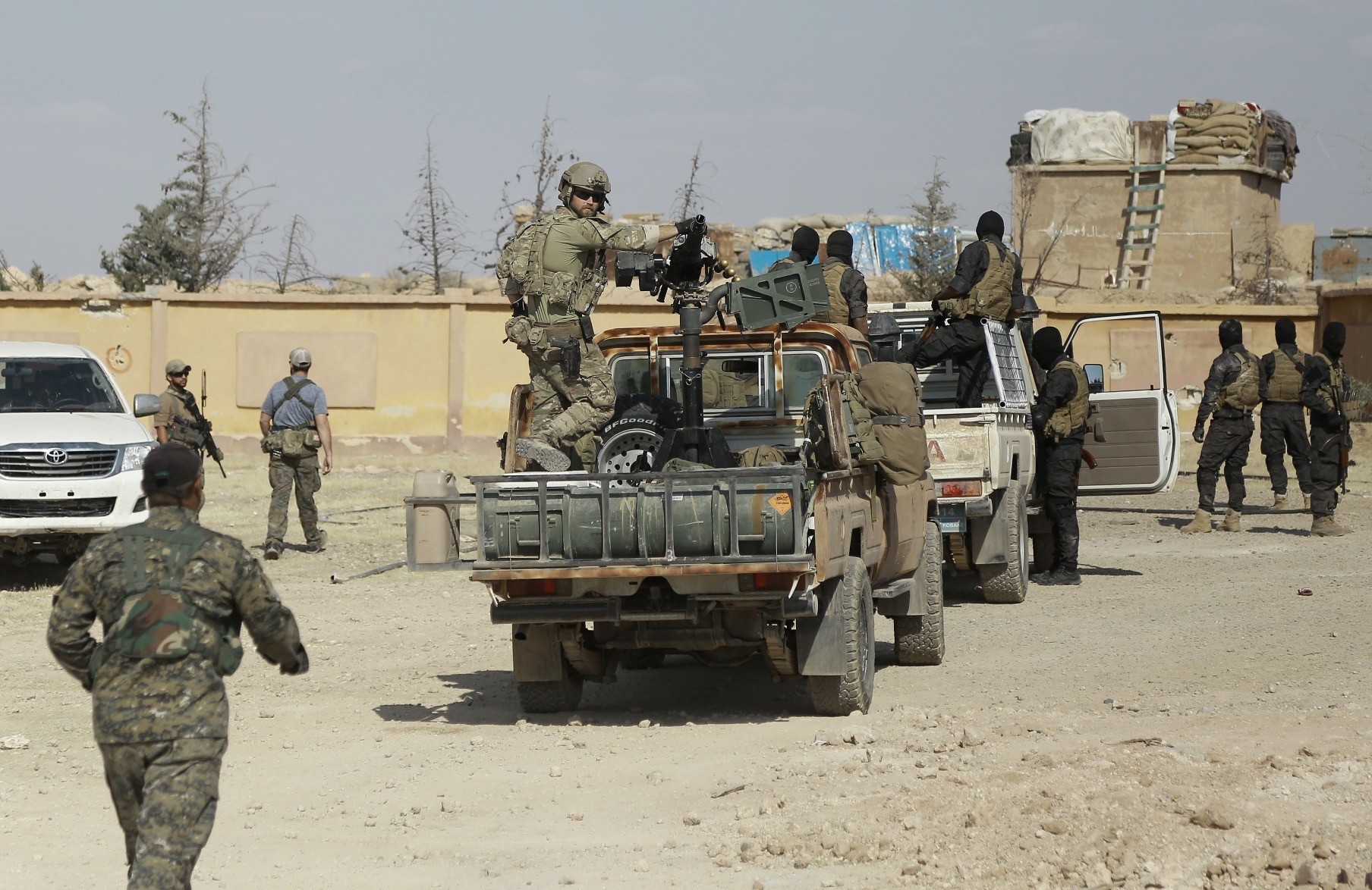 SDF forces and a U.S. soldier in the back of a pickup truck are seen in the village of Fatisah, Raqqa, northern Syria, May. 25, 2016. 