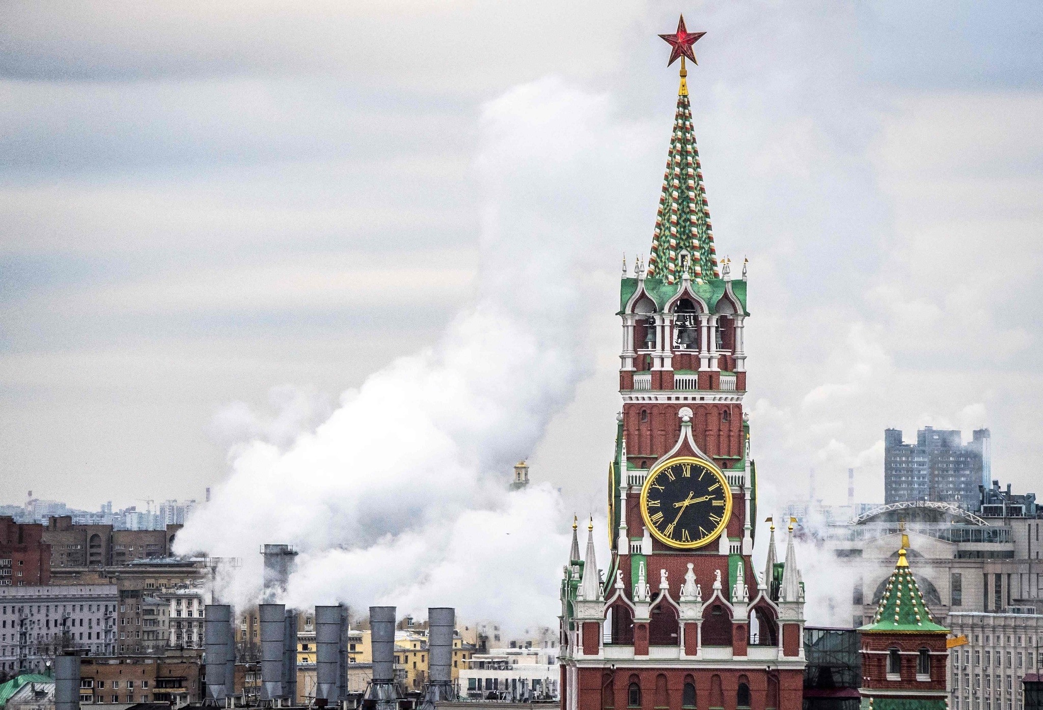 The Kremlinu2019s Spasskaya Tower and a heating power plant in Moscow.