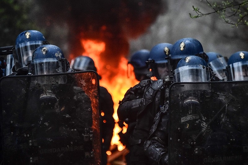 Police riot stand near a barricade in fire during an operation to evict environmental protesters from the site, known as ZAD (AFP Photo)