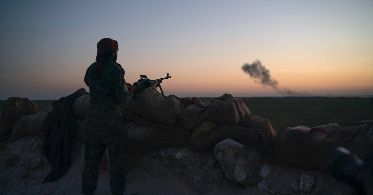 A terrorist from the U.S.-backed and YPG-dominated Syrian Democratic Forces (SDF) scans the desert outside of Baghouz, Syria, Feb. 19, 2019.