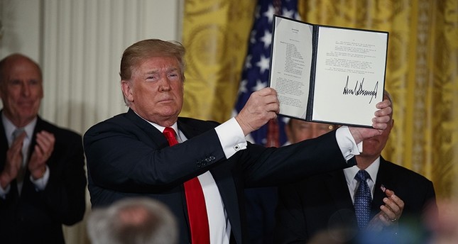 President Donald Trump shows off a Space Policy Directive after signing it during a meeting of the National Space Council in the East Room of the White House, Monday, June 18, 2018, in Washington. (AP Photo)