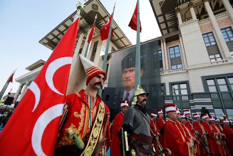 Actors dressed in Ottoman-era warriors' attire stands outside the Presidential Complex decorated with a poster of modern Turkey founder Mustafa Kemal Atatürk, in Ankara.