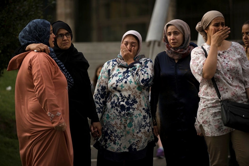 Families of young men believed responsible for the attacks gather along with members of the local Muslim community to denounce terrorism. (AP Photo)