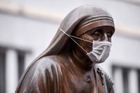 A face mask is placed on the statue of Saint Teresa in Pristina on December 19, 2019. (AFP Photo)