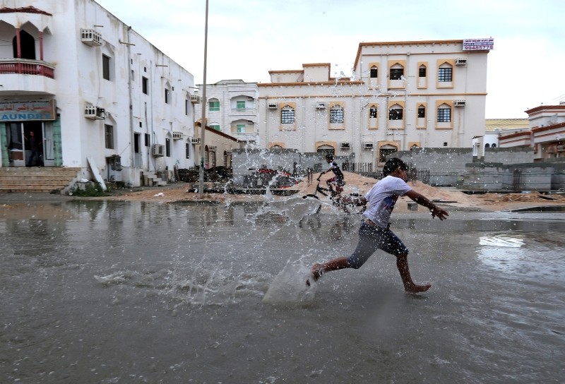 Children from a local neighbourhood play in a roadside puddle accumulated from rain brought by Cyclone Luban in Salalah, Oman, October 13, 2018. (Reuters Photo)