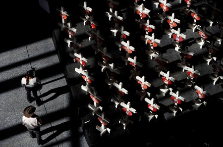 In this Sept. 25, 2018, file photo, people look at a display of wooden crosses and a Star of David on display at the Clark County Government Center in Las Vegas. (AP Photo)