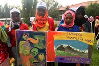 Ethiophian children show the paintings they did.