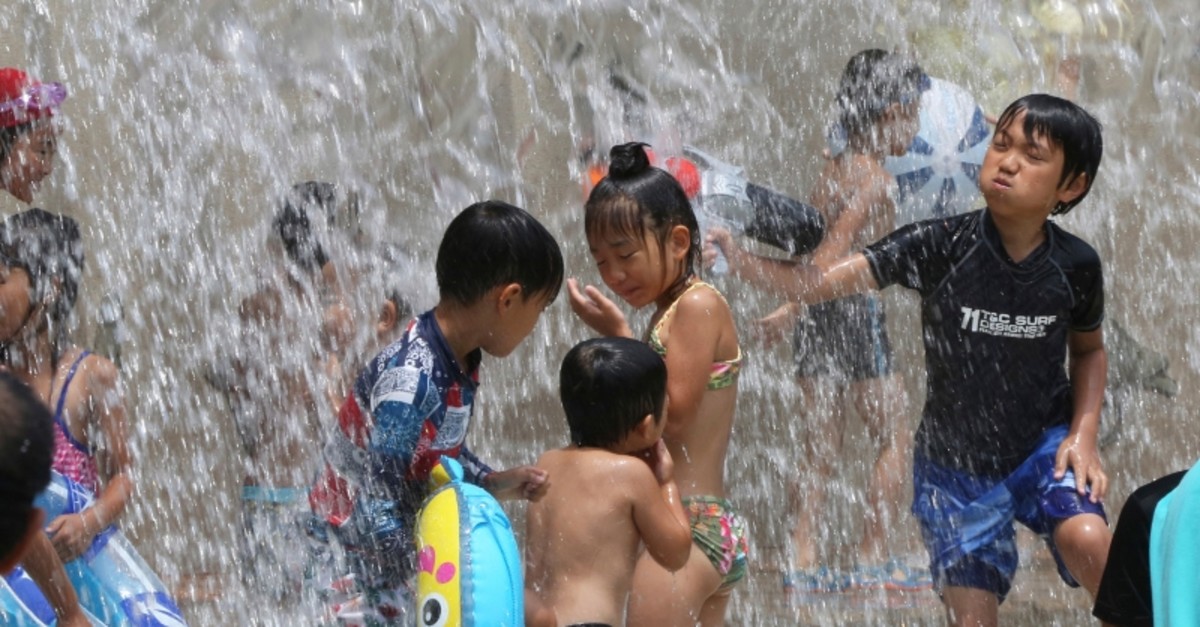 Children play in the water to cool off at a park in Tokyo, Monday, July 16, 2018. (AP Photo)