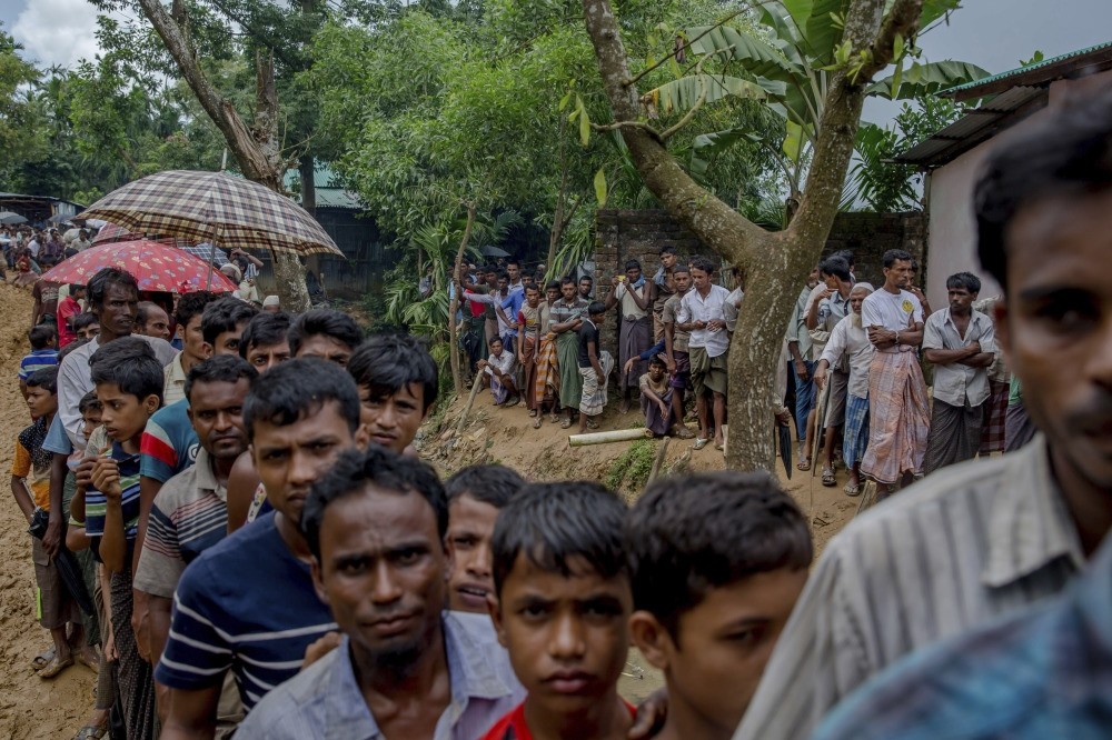 Newly arrived Rohingya wait for their turn to collect shelter building material, distributed by aid agencies in the Kutupalong refugee camp, Bangladesh, Sept. 13. 