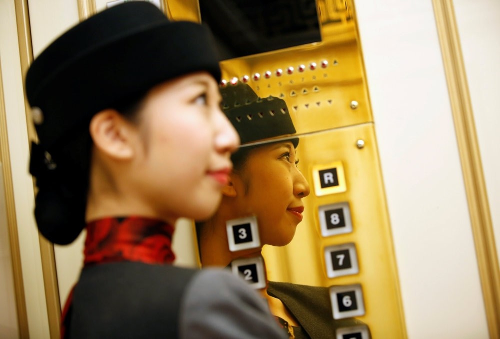 Elevator operator Yuria Nagamoto works at Takashimaya department store in Tokyo, Oct. 18.