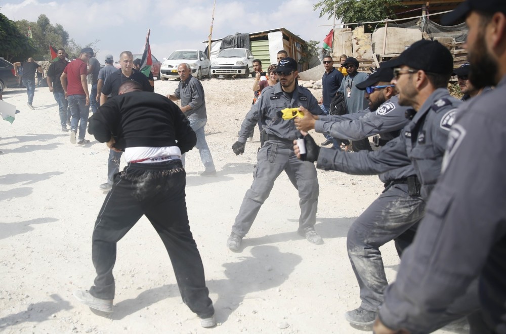 An Israeli policeman tasers a Palestinian activist in the Bedouin village of Khan al-Ahmar, West Bank, Oct. 17.
